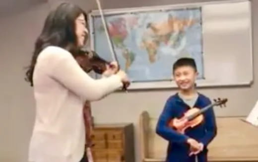 a woman and a man playing a guitar