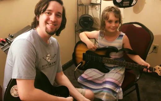 a man and a woman playing guitars