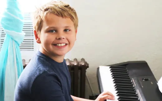 a boy playing a piano