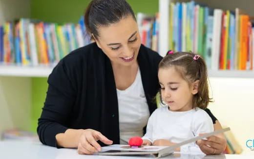 a person and a child looking at a book
