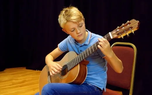 a boy playing a guitar