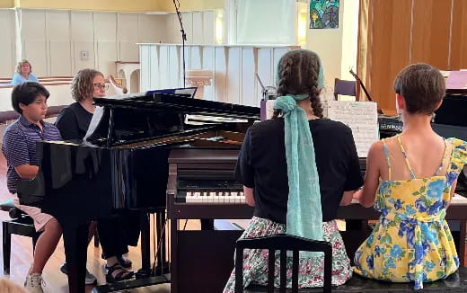 a group of people playing piano