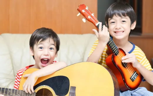 two boys playing guitars