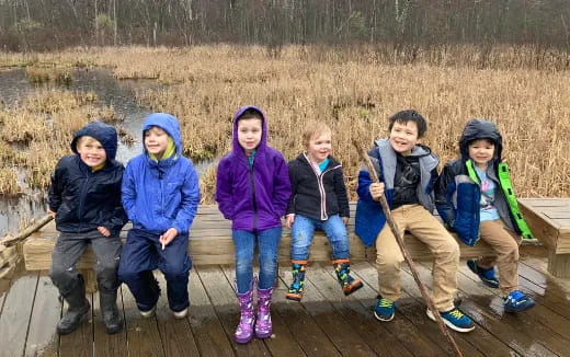 a group of kids sitting on a wooden deck