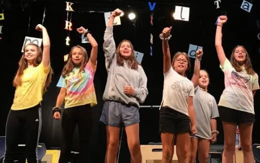 a group of people holding their hands up