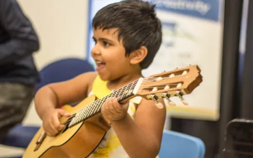 a boy playing a guitar