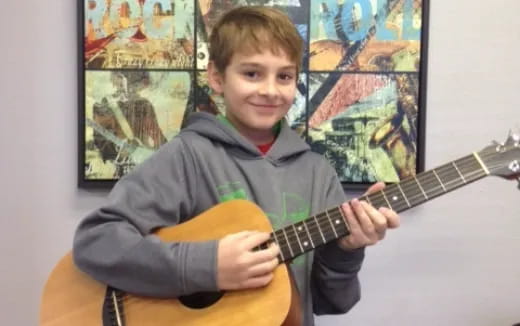 a boy holding a guitar