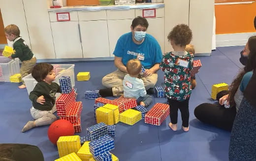 a person and a group of children playing with toys