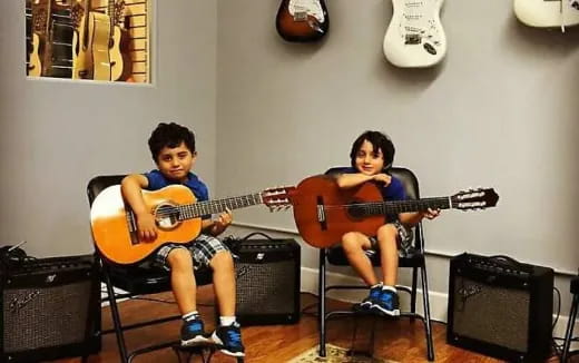 two boys playing guitars