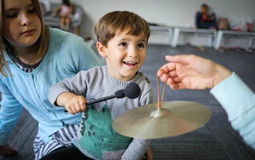 a person and a boy playing with a bowl of water