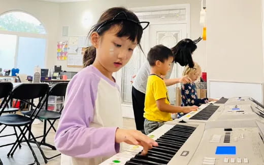 a young girl playing a piano