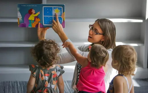 a person and children looking at a poster
