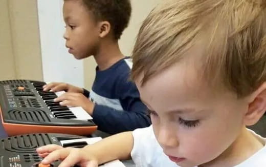 a few young boys playing a piano