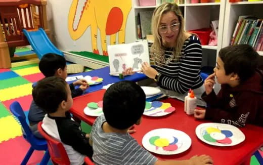 a person reading a book to a group of kids
