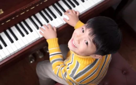 a boy playing a piano