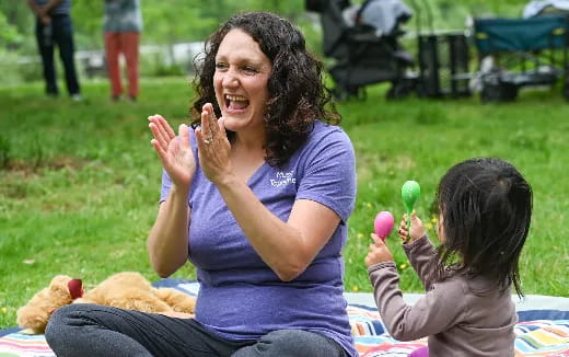 a person and a child sitting on the grass