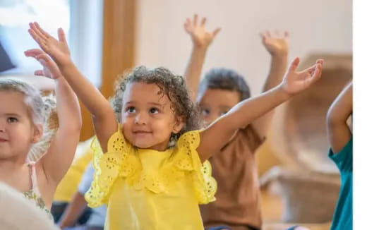 a group of children raising their hands