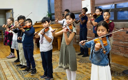 a group of children playing violin