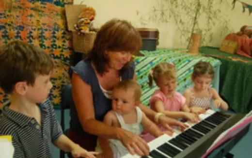 a person playing a piano with children