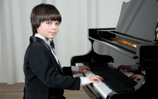 a boy playing a piano