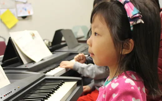 a young girl playing a piano