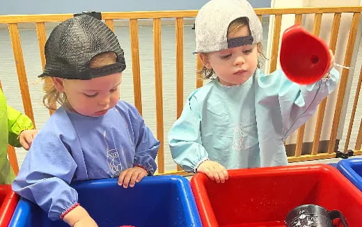 a couple of children playing in a play set