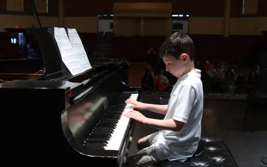 a boy playing a piano