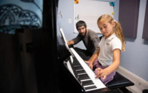 a man and a woman playing a piano