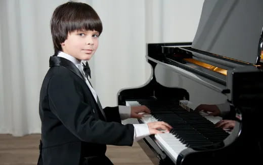 a boy playing a piano