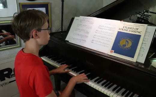 a boy playing a piano