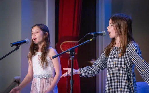 a couple of women singing into microphones