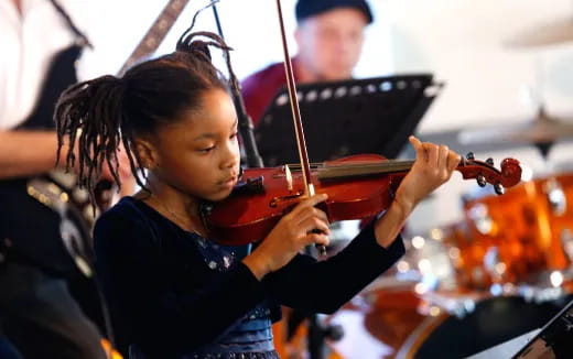 a young girl playing a violin
