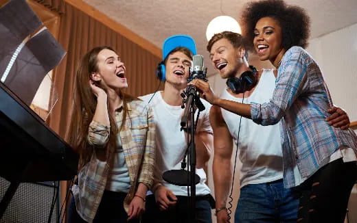 a group of people singing into microphones