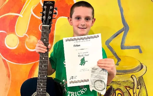 a person holding a guitar and a note