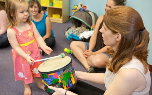 a person playing drums with a group of children