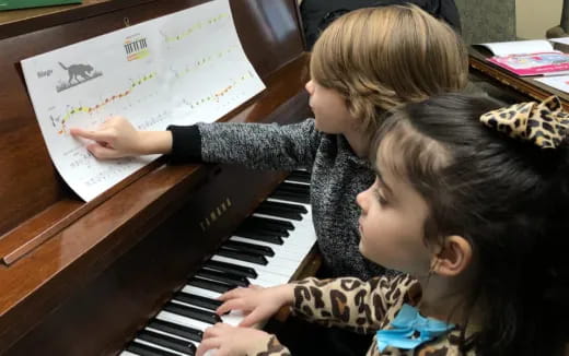 a couple of kids playing piano