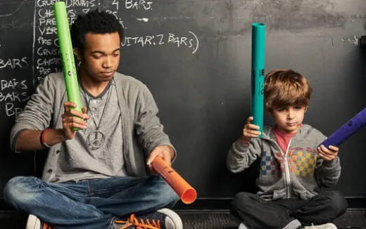 a person and a boy holding baseball bats