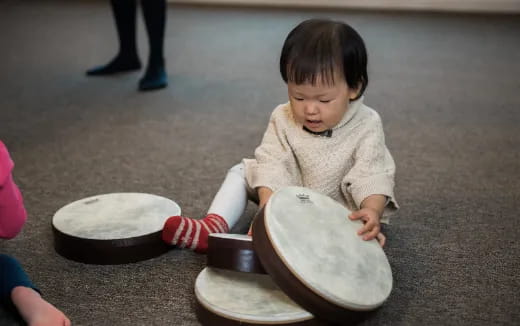 a baby playing with drums