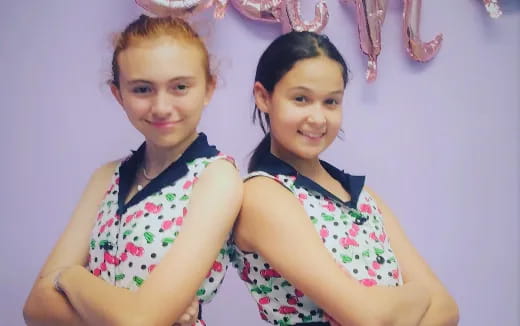 two girls wearing colorful dresses