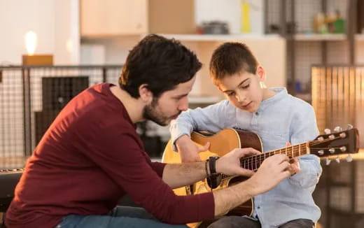 a couple of men playing guitars