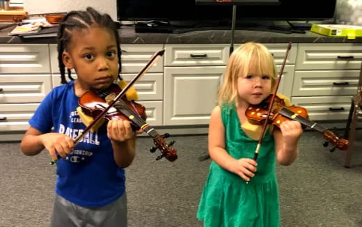 a couple of children playing violin