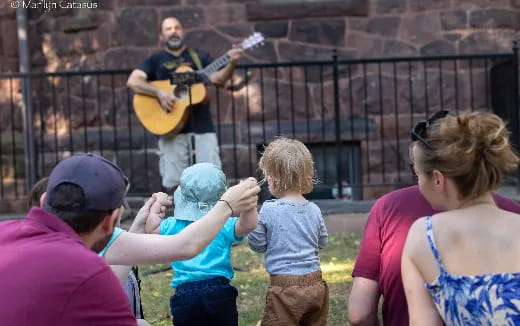 a person playing guitar in front of a group of people
