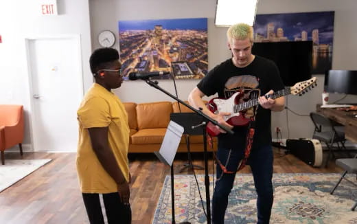 a person playing guitar next to a person playing a guitar