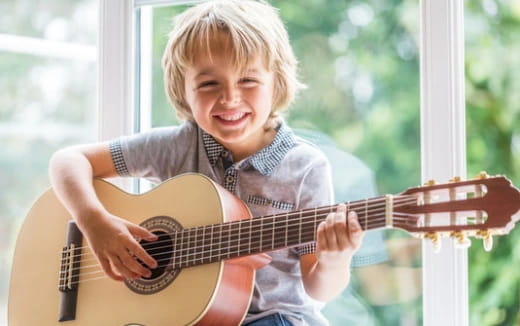 a young girl playing a guitar