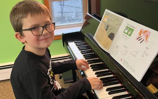 a boy playing a piano