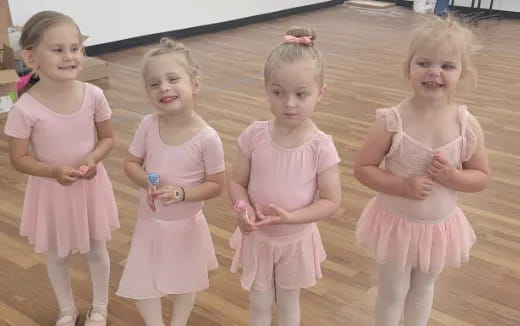 a group of girls in pink dresses
