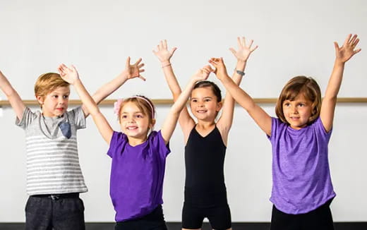 a group of children raising their hands