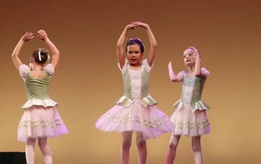 a group of girls wearing dresses and dancing