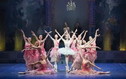 a group of people in dresses dancing on a stage