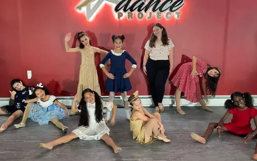 a group of women in dresses and a dog on the floor